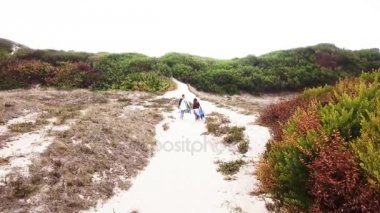 Genç çift dostu sörfçü plaja yürüme