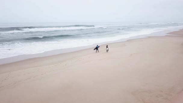 Young couple of friendly surfers wearing wetsuit — Stock Video