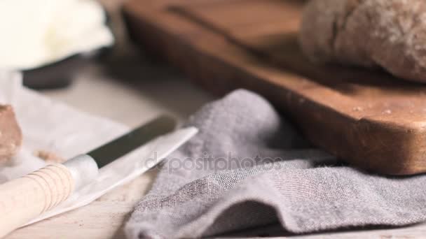 素朴な木製のテーブルでクリーミーなチーズと麦芽パン — ストック動画