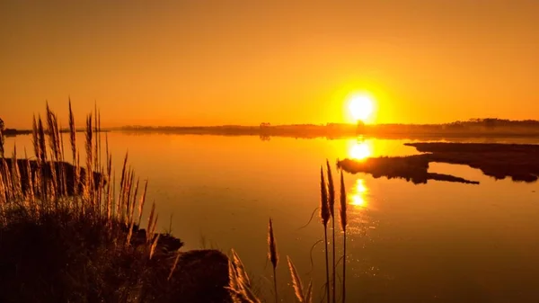 Auringonlasku veden yllä — kuvapankkivalokuva