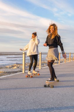 Kaykay ile oynayan iki bayan arkadaş 