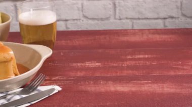 Geleneksel Portekiz aperatif yiyecek. Francesinha sandviç, ekmek, peynir, domuz eti, jambon, sosis, domates bira sos ve patates kızartması. Bira ve patates ile. Masada.