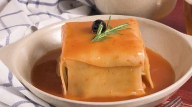 Geleneksel Portekiz aperatif yiyecek. Francesinha sandviç, ekmek, peynir, domuz eti, jambon, sosis, domates bira sos ve patates kızartması. Bira ve patates ile. Masada.