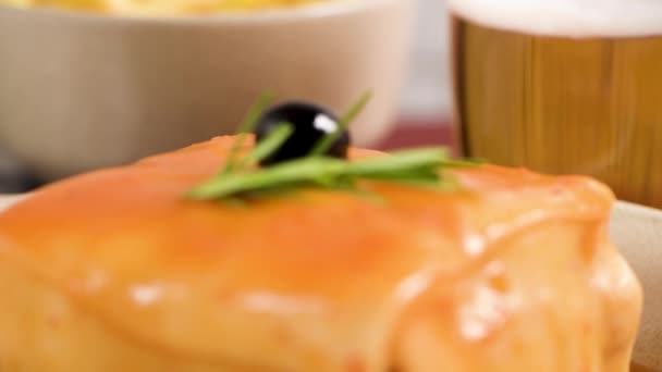 전통적인 포르투갈 음식입니다 Francesinha 샌드위치의 돼지고기 소시지 토마토 소스와 맥주와 — 비디오