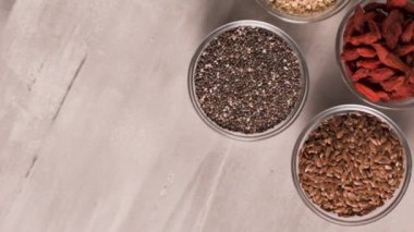 Superfoods ile kopya alanı gri bir arka plan üzerinde. Fındık, fasulye, yeşil ve tohumlar. Sağlıklı vegan gıda.