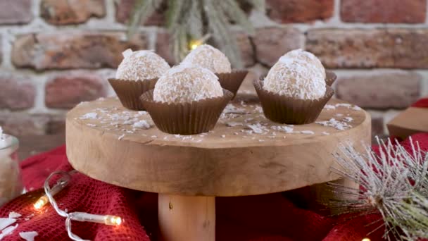 クリスマスのテーブルの上にココナッツローストアーモンドと自家製キャンディーはライトで飾られています — ストック動画