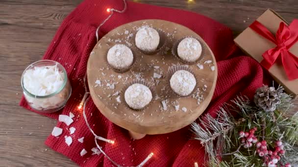 クリスマスのテーブルの上にココナッツローストアーモンドと自家製キャンディーはライトで飾られています — ストック動画