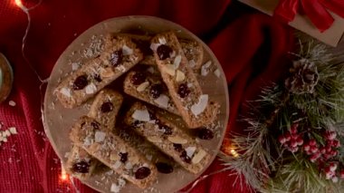 Noel sezonunda ışıklarla süslenmiş bir Noel masasında bademli mısır gevreği, hindistan cevizi ve kızılcık..