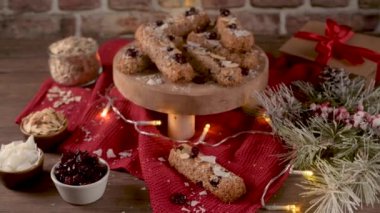Noel sezonunda ışıklarla süslenmiş bir Noel masasında bademli mısır gevreği, hindistan cevizi ve kızılcık..
