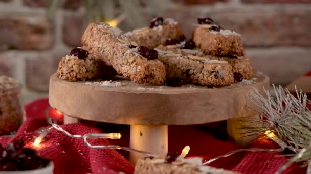 Müsliriegel Mit Mandeln Kokos Und Preiselbeeren Auf Einem Weihnachtlich Beleuchteten — Stockvideo