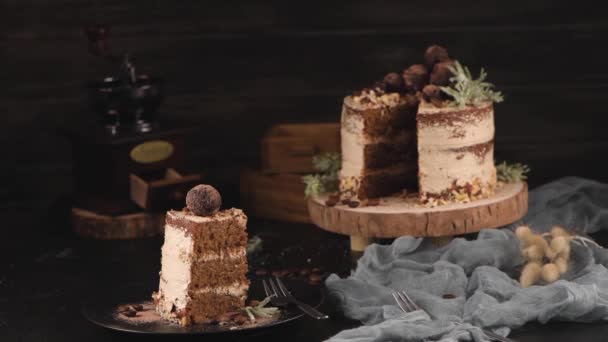 テーブルの上においしい裸のコーヒーとヘーゼルナッツケーキのスライス素朴な木のキッチンカウンタートップ — ストック動画
