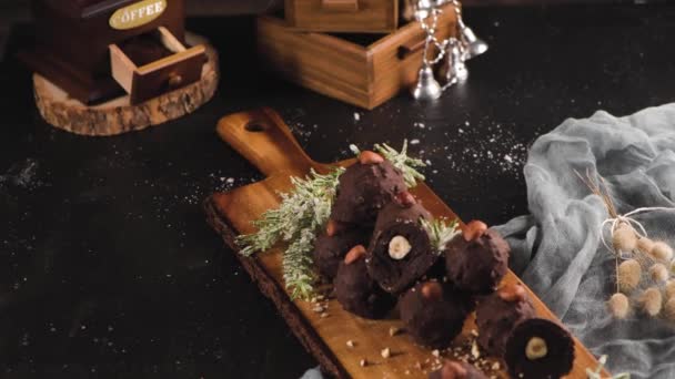 ダークチョコレートトリュフとともにヘーゼルナッツ上の木のまな板 — ストック動画