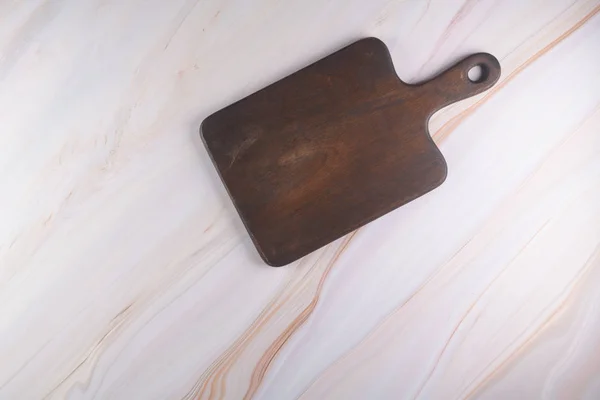 Tabla de cortar de madera sobre un fondo de mármol gris — Foto de Stock