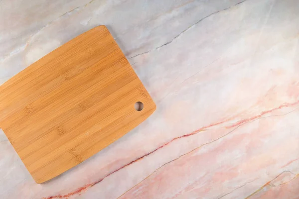 Tabla de cortar de madera sobre un fondo de mármol gris — Foto de Stock