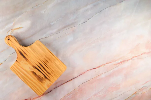 Tabla de cortar de madera sobre un fondo de mármol gris — Foto de Stock