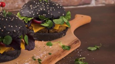 Lezzetli ızgara vejetaryen burger, mercimek, kuru domates ve ahşap tezgahta siyah ekmek..