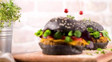 Lezzetli ızgara vejetaryen burger, mercimek, kuru domates ve ahşap tezgahta siyah ekmek..