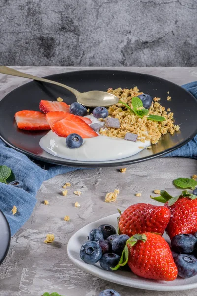 Ripe blueberries and strawberries with yogurt and granola — Stock Photo, Image