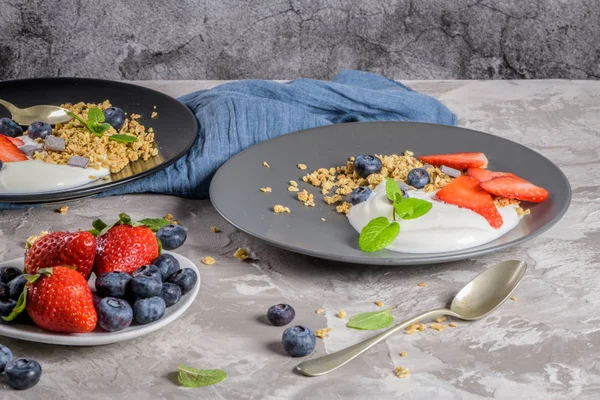 Ripe blueberries and strawberries with yogurt and granola — Stock Photo, Image