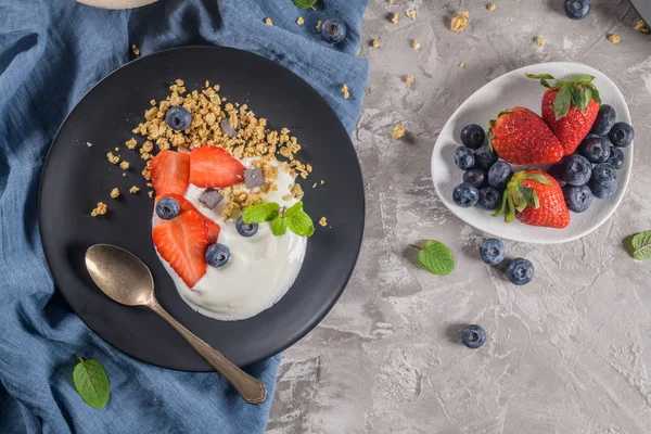 Ripe blueberries and strawberries with yogurt and granola — Stock Photo, Image