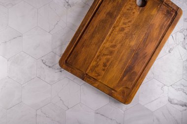 Modern altıgen desenli mermer taş tezgahın ahşap kesim tahtasının üst görüntüsü.