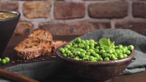 素朴なキッチンカウンターの上に リネードとカボチャとひまわりの種と緑のエンドウ豆のスープ — ストック動画