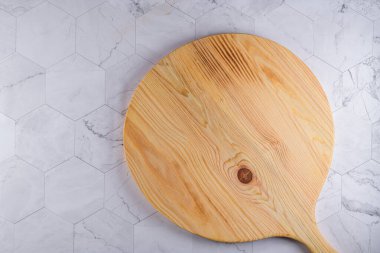 Modern altıgen desenli mermer taş tezgahın ahşap kesim tahtasının üst görüntüsü.