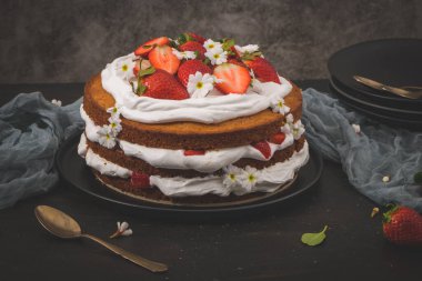 Çilekli pasta, çilekli kek taze çilek ve koyu mutfak tezgahında ekşi krema..