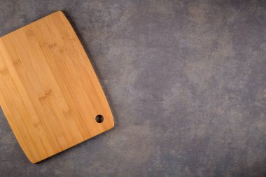 Ahşap kesme tahtası üstten görünüm eski taş tezgah üzerinde.