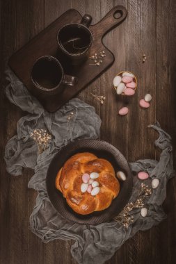 Ahşap masanın üstünde şeker bademleri olan Paskalya folar..