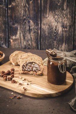 Vejetaryen çikolatası organik badem yağından, organik kakao ve baldan yapılmış, koyu kırsal mutfak tezgahında..