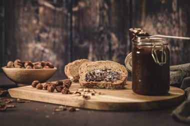 Vejetaryen çikolatası organik badem yağından, organik kakao ve baldan yapılmış, koyu kırsal mutfak tezgahında..