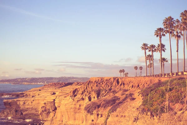 ビンテージ スタイルを見るカリフォルニア州サンディエゴ アット サンセット クリフズのポイント ヤシの木 太平洋 岩の多い海岸線とレトロなトーン フィルター — ストック写真