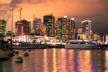 Tekneler, aydınlatılmış binalar ve su ile San Diego California güzel gece görmek