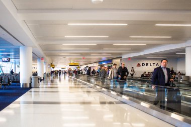 New York City, New York, USA - April 27, 2018:  View inside John F. Kennedy International Airport at the Delta Airlines gate on a typical morning with passengers in view. clipart