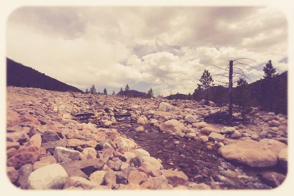 视图从落基山国家公园在科罗拉多与小河在岩石风景 山和不祥的天空 图像有复古色调滤镜 — 图库照片