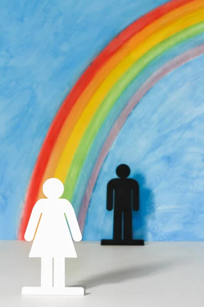 Ícones de homem e mulher com um arco-íris e céu azul — Fotografia de Stock