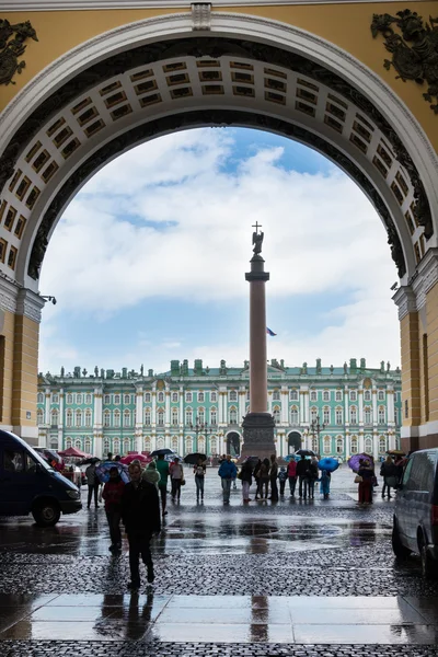 Tourists hiding from the rain under the arch of the General Staf — Stock Photo, Image