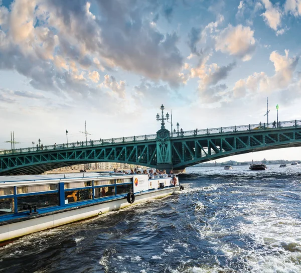 Pleasure boat floats on the background of the bridge — Stock Photo, Image