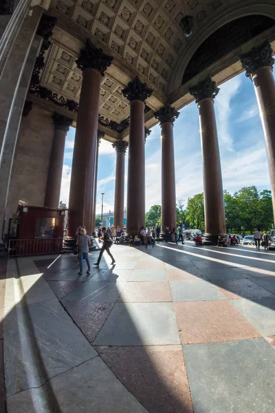 Tourists walk in the shadow of the majestic columns of St. Isaac — Stock Photo, Image