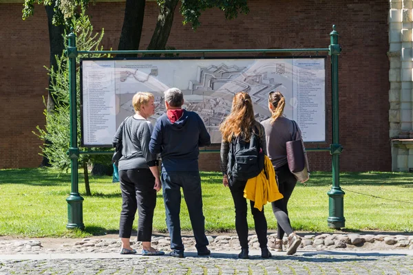 Tourists crowd around the map of the fortress on the paved area. — Stock Photo, Image