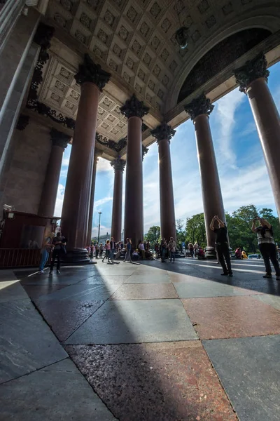 Turister vandrar i skuggan av de majestätiska kolumnerna i St. Isaac — Stockfoto