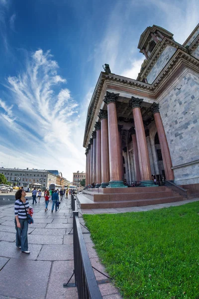 Los turistas caminan a la sombra de las majestuosas columnas de San Isaac — Foto de Stock