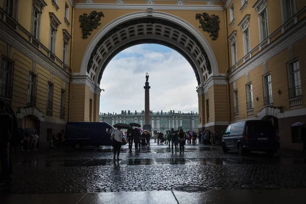 Tourists hiding from the rain under the arch of the General Staf — Stock Photo, Image