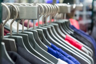 Askılarda farklı giysiler. Kapatın.