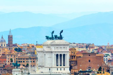 Roma 'nın çatıları tarafından çerçevelenmiş Altare della Patria manzarası