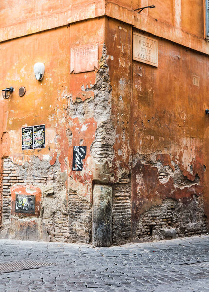 Rome, Italy - Oct 05, 2018: Collapsed plaster exposed the ancient masonry of the house at the corner of the Vicolo delle Vacche in Rome