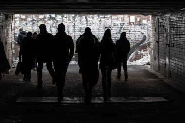 Alt geçitteki yayaların siluetleri