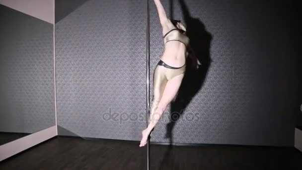 Flicka i guld dansar poledance — Stockvideo