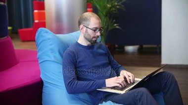 Dizüstü bilgisayarda çalışma gözlüklü adam